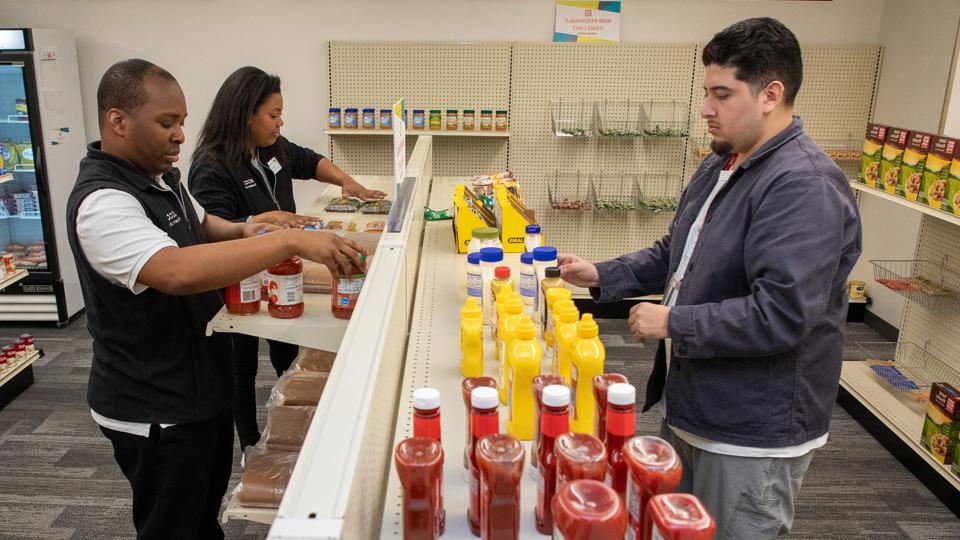 Student volunteer stocking shelves in the Basic Needs Center